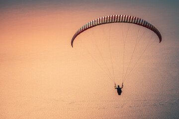 Paragliding in the sky at sunset. Paraglider flying over the Oludeniz Beach. Babadag, Fethiye,...