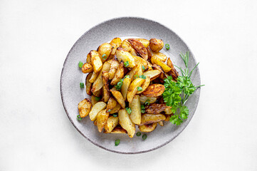 Roasted new potatoes, baked baby potatoes in a plate with herbs. Gray background.