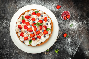 cheesecake with strawberry and fresh berries on black background, delicious strawberry tart pie or cake, banner, menu, recipe place for text, top view