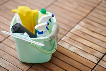 Close-up of bucket with sprays, garbage bag and rag for cleaning of apartment or house
