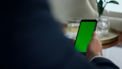 Closeup man use chroma key smartphone. Businessman hand touch green screen phone