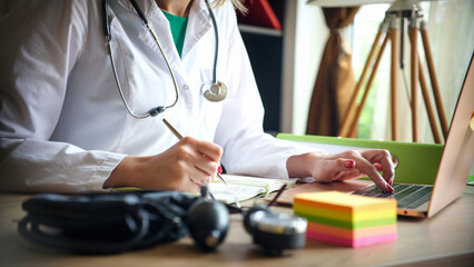 Female doctor working on laptop in clinic office