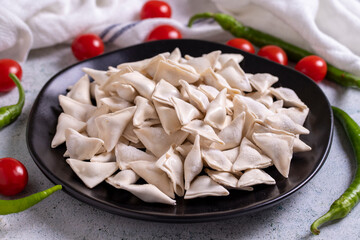 Frozen ravioli on stone floor. Stuffed ravioli in the middle. Turkish ravioli. Traditional world cuisine delicacies. Close-up.