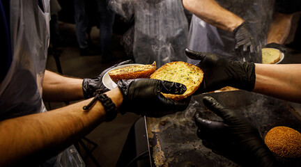 Fried buns in the hands of a chef with black gloves