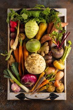 Assortment of Vegetables and root vegetables in wooden tray. Autumn harvest. Healthy food and vegetarian concept.