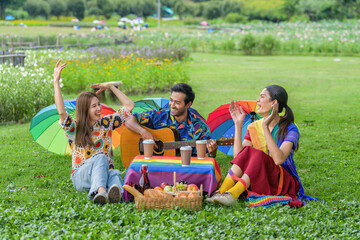 transgender person with LGBTQ friends enjoying together at picnic in park