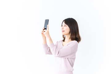 笑顔でスマホ撮影をする若い女性