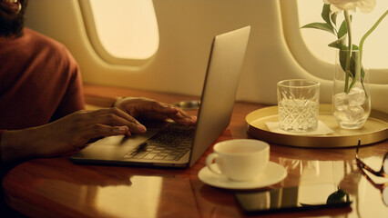 Successful manager working laptop on airplane. Closeup hands typing keyboard