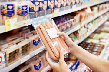 Sausages in hands of buyer in shop