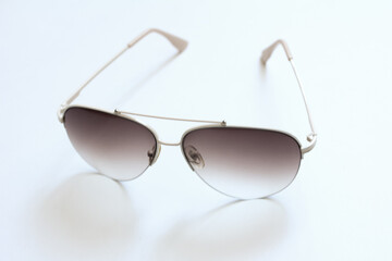 Glasses with gradient filled lenses, aviator glasses on a white background, selective focus