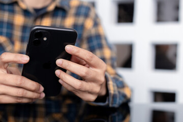 using cell phone hand holding mobile texting message contact us.chatting,search internet information in office.technology device communication connecting