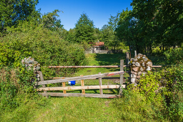 Wooden gate at a dirt road to a cottage
