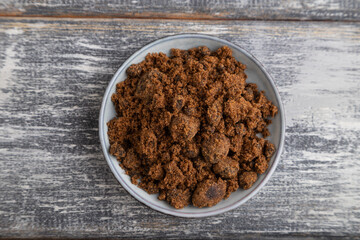 plate with unrefined cane sugar on gray wooden. top view, close up.