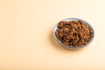 plate with unrefined cane sugar on orange pastel. side view, copy space.