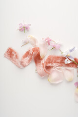 Jewelry and decor for the bride. Wedding composition, light pink velvet ribbon on a white background with flower petals