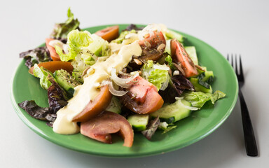 vegetable salad of greens, tomatoes and cucumbers on a green plate