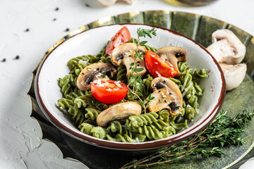 Mushroom and Spinach Pasta in a Bowl, Vegan Food on light background. Vegan or gluten free diet. banner, menu recipe place for text, top view