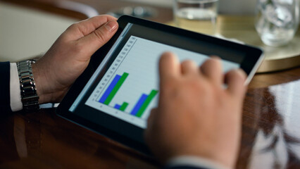 Finance professional using tablet. Closeup man hands touch pad screen graphics