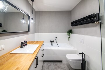 Fototapeta na wymiar Modern bathroom with a wash basin, a wooden countertop and white furniture