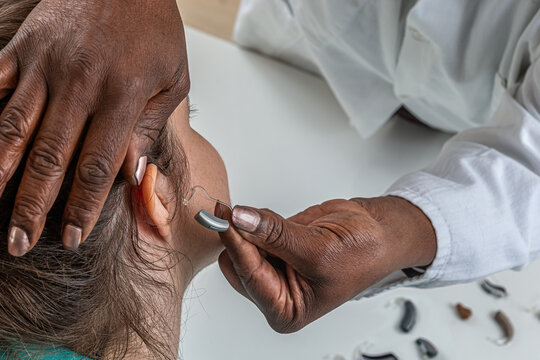 Hearing care professional trying a hearing aid