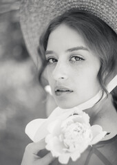 Close-up black and white portrait of a cute blonde in a straw hat at sunset. Vintage tone..Soft...