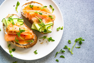 Open sandwich with cream cheese, salmon and cucumber. Healthy breakfast or snack. Top view with copy space.