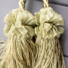 Texture of synthetic golden threads. Gold tassels made of cord, ropes on curtains with bows made of silk ribbonHigh quality photo