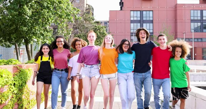 Colorful group of teenagers walking with arms around