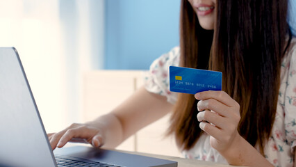 Close-up of an Asian woman's hand holding, credit cards, flipping over, to browse the credit cards that will be used to pay for online purchases, online shopping.