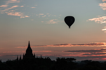 Fototapeta na wymiar Bagan, Myanmar : view on a Buddhist temple in the ancient city of Bagan, Myanmar at sunrise with a hot air balloon in the sky