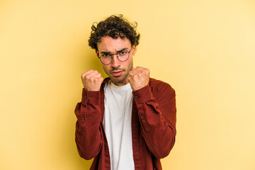 Young caucasian man isolated on yellow background upset screaming with tense hands.
