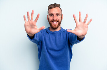 Fototapeta premium Young caucasian man isolated on blue background showing number ten with hands.