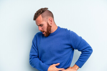 Obraz premium Young caucasian man isolated on blue background suffering a back pain.