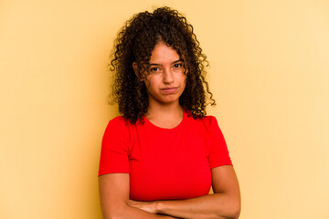 Young Brazilian woman isolated on yellow background suspicious, uncertain, examining you.