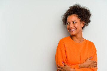 Young Brazilian woman isolated on blue background smiling confident with crossed arms.