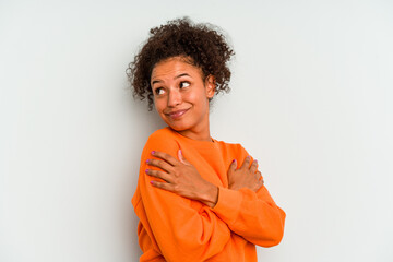 Fototapeta na wymiar Young Brazilian woman isolated on blue background hugs, smiling carefree and happy.