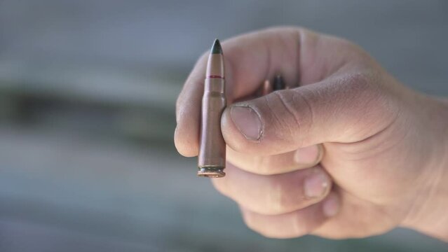 Armor-piercing cartridge 7.62x39 mm close-up holden in fingers
