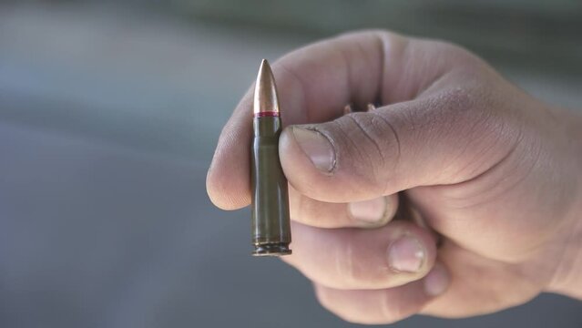 Regular cartridge 7.62x39 mm close-up holden in fingers
