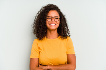 Young Brazilian woman isolated on blue background who feels confident, crossing arms with determination. - obrazy, fototapety, plakaty