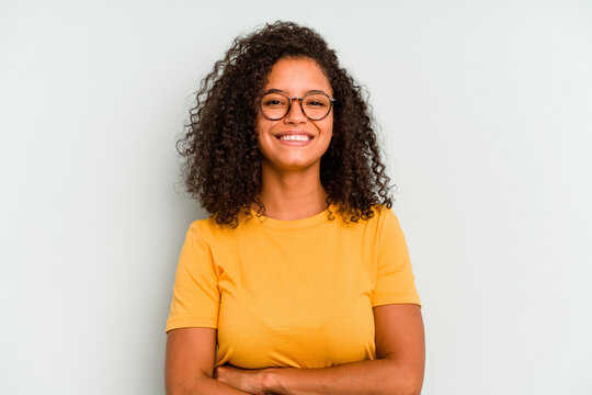 Young Brazilian woman isolated on blue background who feels confident, crossing arms with determination.