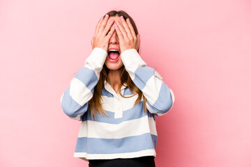 Young caucasian pregnant woman isolated on white background having fun covering half of face with palm.