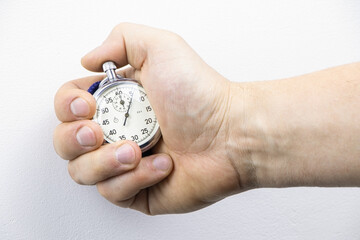 Analog stopwatch close-up. Man's hand holding a stopwatch.Counting time by stopwatch. Time...
