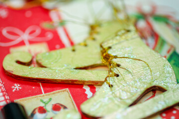 Macro of the painted wooden Christmas decoration (green skates). New year, winter holidays concept background. Creativity, DIY, hobby
