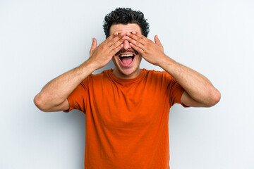 Young caucasian man isolated on blue background covers eyes with hands, smiles broadly waiting for a surprise.