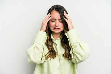 Young caucasian woman isolated on white background having a head ache, touching front of the face.