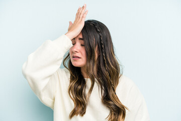 Fototapeta premium Young caucasian woman isolated on blue background forgetting something, slapping forehead with palm and closing eyes.