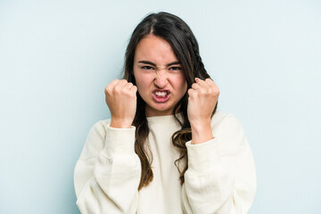 Young caucasian woman isolated on blue background upset screaming with tense hands.