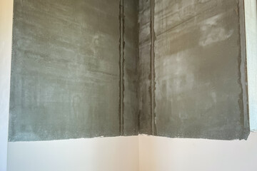 Applying a layer of putty on plastered walls. Apartment renovation.