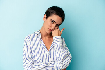 Young caucasian woman isolated on blue background tired of a repetitive task.