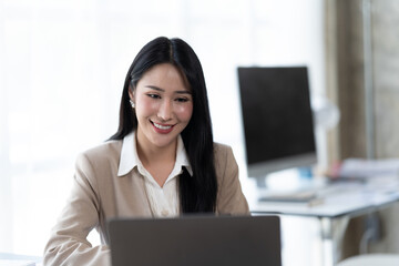 Asian woman working with laptop in her office. business financial concept.